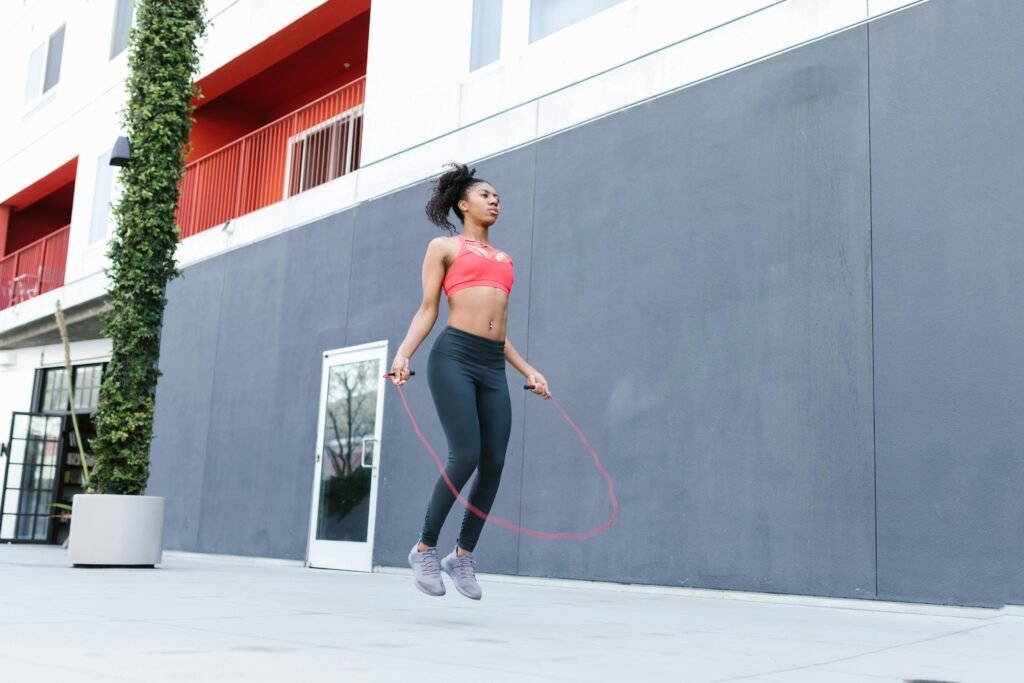 Fit woman in athletic wear jumping rope outdoors – high-intensity cardio workout for lose weight and endurance